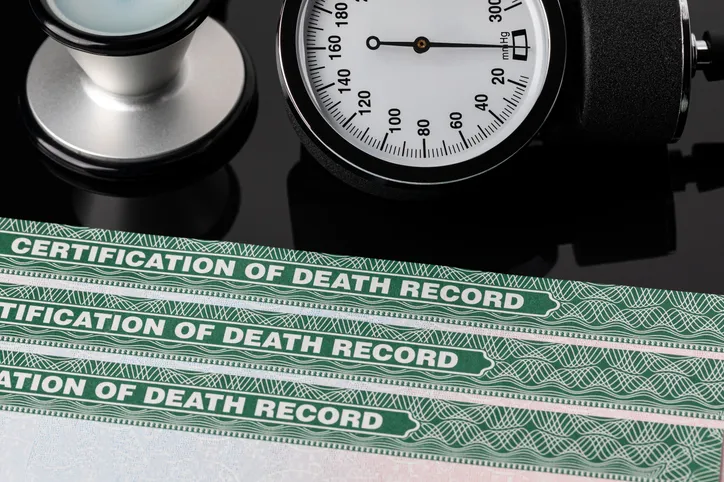 Certificados de defunción junto a un tensiómetro y un estetoscopio médico
