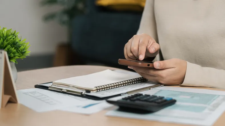 Cálculo de gastos o impuestos con calculadora y documentos