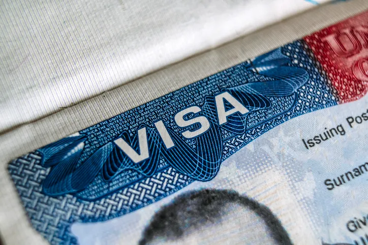 Primer plano de un visado estadounidense en un pasaporte, mostrando la palabra 'VISA' y datos personales parcialmente visibles.