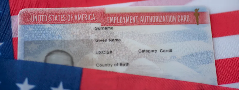 Tarjeta de autorización de empleo de Estados Unidos sobre la bandera estadounidense, con campos para nombre, apellido y número USCIS.