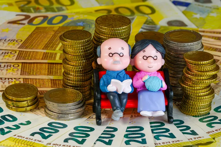 Figuras de una pareja de ancianos en un banco rodeadas de monedas y billetes de 200 euros