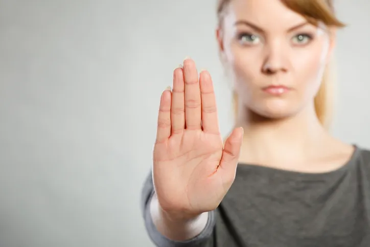Mujer haciendo un gesto de stop con la mano en señal de rechazo o negativa