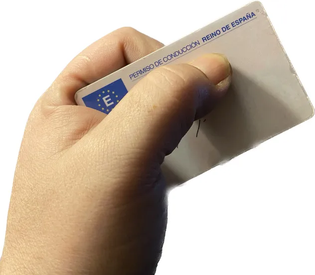 Mano sujetando el carnet de conducir español con la bandera de la Unión Europea