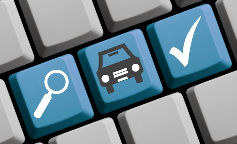 Teclado con teclas destacadas de lupa, coche y verificación para simbolizar la consulta de un vehículo