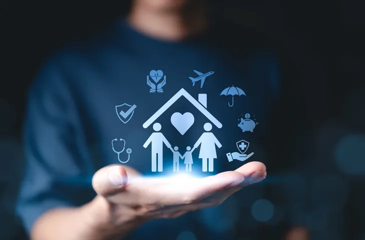 Persona sosteniendo iconos de seguros de hogar, salud, viaje y familia sobre la palma de la mano